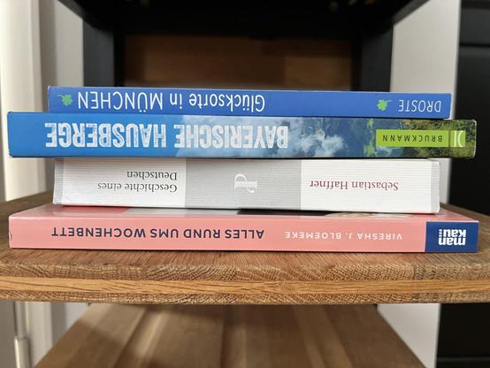 4 Buchrücken: zwei bayrische Reiseführer, „Geschichte eines Deutschen“ von Sebastian Haffner und „Alles rund ums Wochenbett“.
