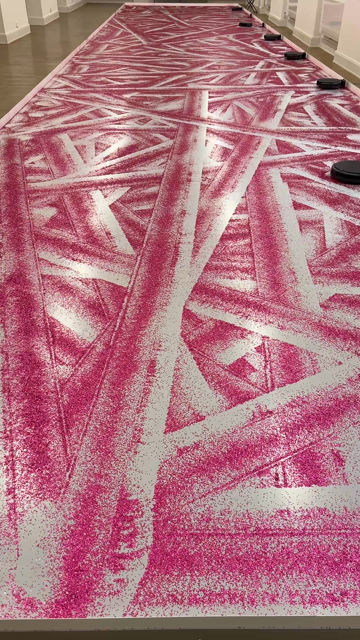 Putzroboter auf einem Boden voller Glitter welche Spuren hinterlassen. 